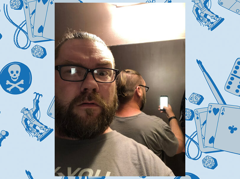 Todd using a mirror to show off his ponytail.